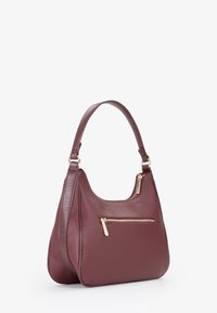 Borsa a mano in pelle bordeaux con finitura testurizzata, forma curva e dettagli in zip dorata. Presenta una tracolla singola e una tasca con zip esterna.