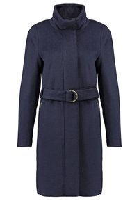 Long manteau bleu marine avec col haut, ceinture en tissu assorti avec boucle circulaire dorée et poches latérales zippées.