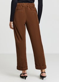 Braune Cordhosen mit elastischem Bund, gerade geschnittenen Beinen und umgeschlagenen Säumen, ausgestattet mit zwei Gesäßtaschen für zusätzlichen Nutzen.