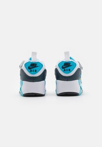 Sneakers Nike Air con una toma bianca e accenti blu e grigi, un colletto imbottito e una suola texturizzata per la trazione.