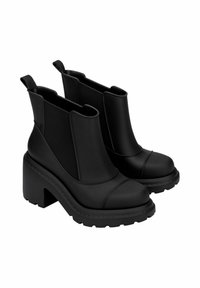 Bottes noires à la cheville avec un large talon, des panneaux latéraux en élastique et du cuir synthétique lisse. Semelles texturées pour une adhérence et une durabilité accrues.