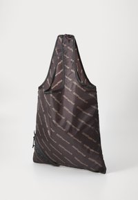 Sötétbarna, újrahasználható vászontáska, ismétlődő logómintával. Simaszerkezet jellemzi, és egy külső cipzáras zsebvel rendelkezik a további tárolás érdekében.