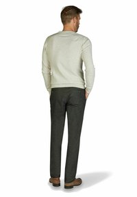 Hellgrauer Pullover aus weichem Stoff, kombiniert mit dunkelgrauen Maßhosen. Braune Schuhe sichtbar, im Stehen, Rückansicht.