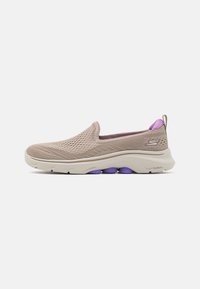Sapatilhas slip-on em malha bege com detalhes em roxo. Apresenta um bico arredondado, parte superior texturizada e uma entressola branca acolchoada. Design leve.