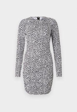 Langærmet kjole i et sort-hvidt prikket mønster, med en rynket halsudskæring og en tætsiddende silhuet med rynke-detaljer.