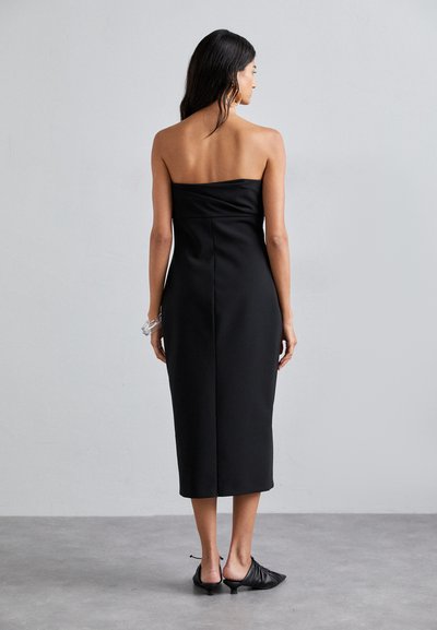 Schwarzes trägerloses Kleid mit tailliertem Oberteil, knielangem Schnitt und glatter Textur. Ausgestattet mit einem Reißverschluss auf der Rückseite und minimalen Nähten.