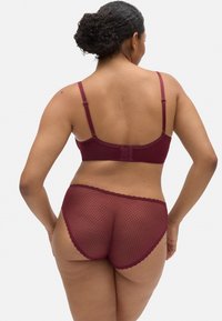 Conjunto de sujetador y braga burdeos con diseño de malla texturizada, tirantes ajustables y bordes con puntas, vista desde atrás.