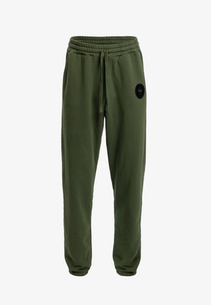 Olijfgroene katoenen joggers met een elastische tailleband, trekkoord en gekuifte enkels, met een cirkelvormige zwarte logopatch op de linkerdij.