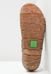 Bruine rubberen zool met een gestructureerde grip, voorzien van een groene logo en gegraveerd "EL NATURALISTA." Kenmerkend gespikkeld patroon zichtbaar.