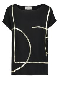 Blusa nera con motivi geometrici metallici dorati. Dotata di maniche corte e scollatura rotonda, realizzata in un tessuto liscio, con vestibilità rilassata.