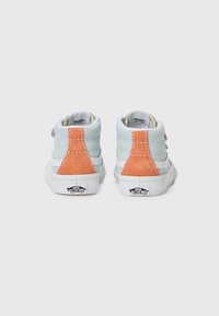 Baskets montantes avec une tige en daim bleu clair, accents orange et violet, semelle en caoutchouc blanche et logo sur le talon.