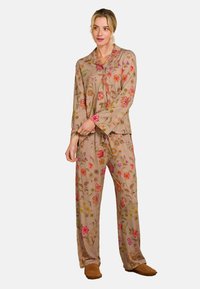Blumenmuster-Pyjama-Set aus hellbraunem Stoff; Oberteil mit langen Ärmeln und passenden Hosen. Enthält bunte gestickte Blumen und eine lässige Passform.