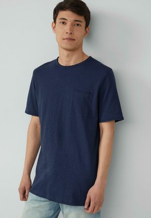 Donkerblauwe T-shirt met korte mouwen en een ronde hals, voorzien van een borstzak, gemaakt van zacht materiaal met een gladde textuur.