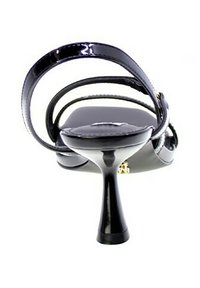 Sandal con tacco alto nero con finitura lucida in vernice, caratterizzato da sottili cinturini e un design del tacco appuntito. La suola è liscia e leggermente sagomata.