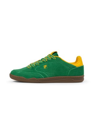 Gröna mockasneakers med gula detaljer och snören, med en brun gummisula och logotypdetalj på sidan.