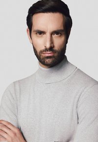 Jasnoszary sweter w golfie wykonany z miękkiego materiału, z prążkowaną teksturą i dopasowanym krojem. Gładkie wykończenie z delikatnymi detalami szwów.