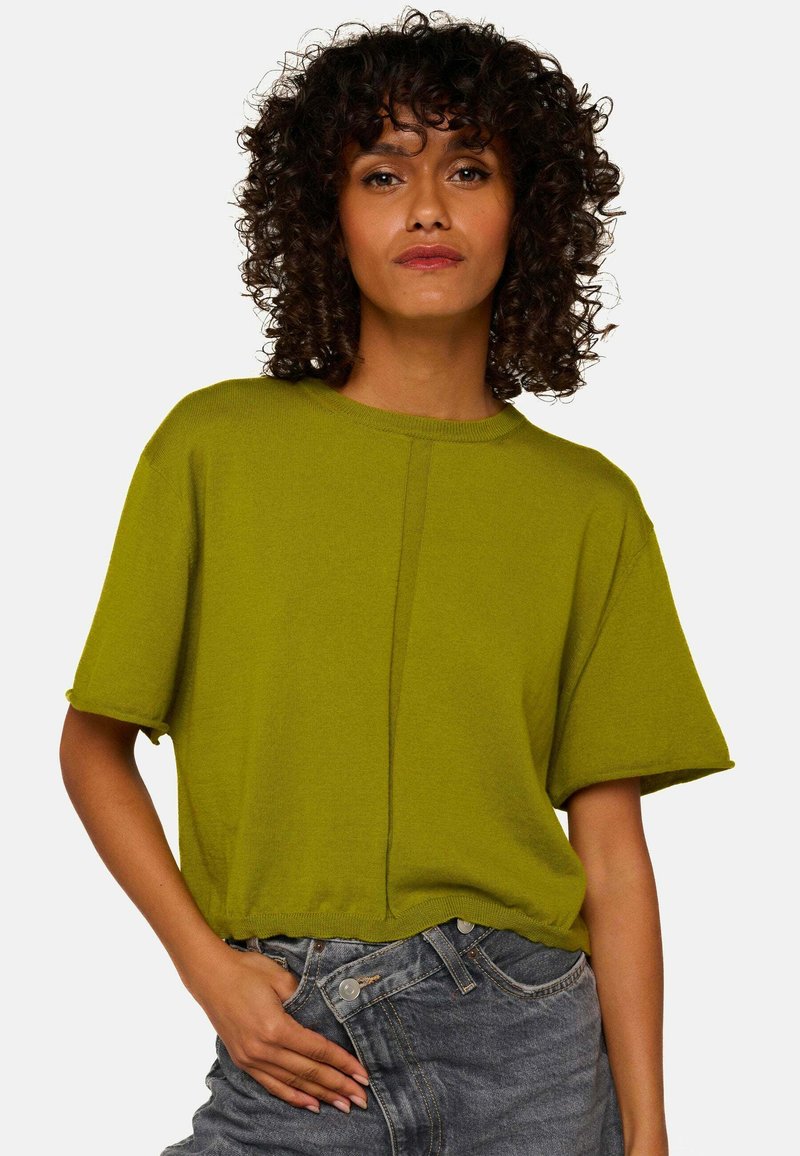 T-shirt à manches courtes olive en tricot avec une coupe décontractée, doté d'un col rond et d'un détail de couture sur le devant. Associé à un short en jean.