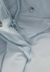 Lys blå stofinteriør med en lynlås og en trykknap. Har et struktureret foring og lys blå nylon snor med plastspidser.