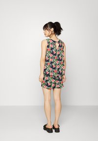 Vestido sem mangas floral com fundo azul-marinho, apresentando padrões em rosa e verde, decote em forma de colher e detalhe nas costas em forma de olho-chave.