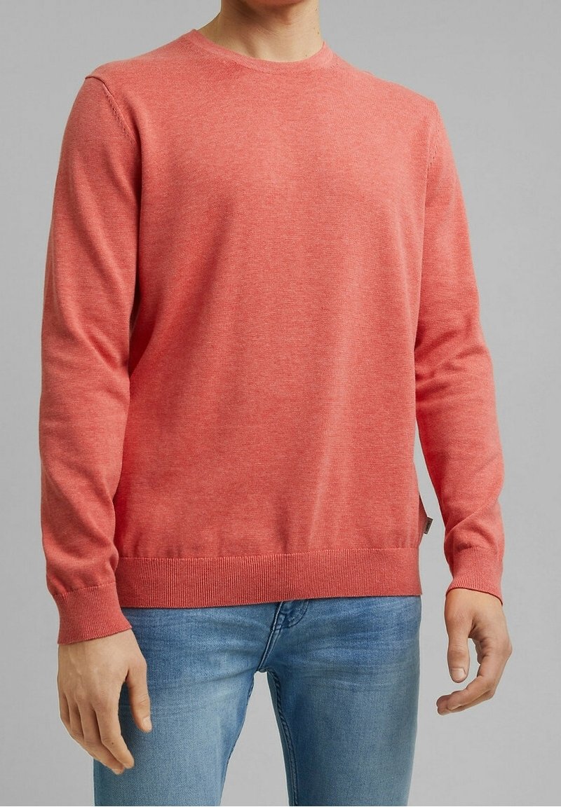 Korallenroter Pullover aus weichem Strickmaterial, mit Rundhalsausschnitt, langen Ärmeln und geripptem Saum und Bündchen. Lässiges Design, schlichte Textur.