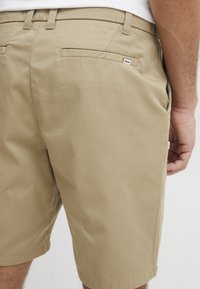 Khakifarbenen Shorts aus Baumwollstoff, mit einer Gesäßtasche, gesticktem Saum und zarter Stickerei am Bein.