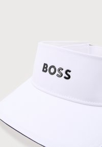 Λευκό καπέλο-visor με μαύρα γράμματα "BOSS" κεντραρισμένα στην μπροστινή ταινία, με καθαρές ραφές και κυρτή γείσο.