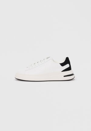 White sneaker with a smooth leather upper, black suede heel accent, flat laces, and a textured rubber sole. Notable logo detail on side.