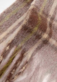 Tissu en laine doux et texturé présentant un mélange de rayures roses, marron et vertes. Des fibres légères créent une apparence empilée et floue.