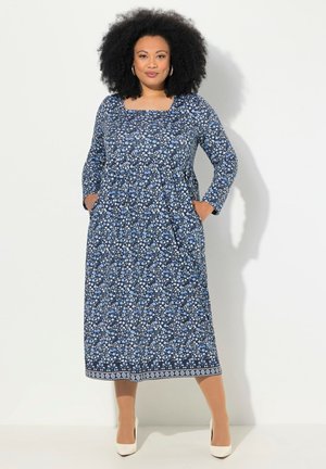 Blaues Blumen-Midikleid mit langen Ärmeln, quadratischem Ausschnitt, Taschen und weißen Akzenten am Saum. Hergestellt aus leichtem Stoff.