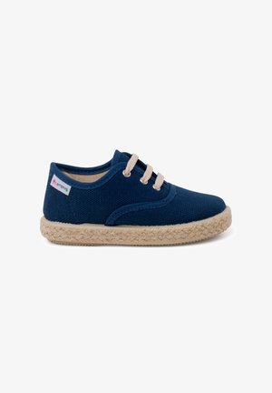 Marineblauwe canvas schoen met beige veters, ronde neus en espadrille-stijl jute zool. Heeft zijnaadstiksels en een klein multicolor label.
