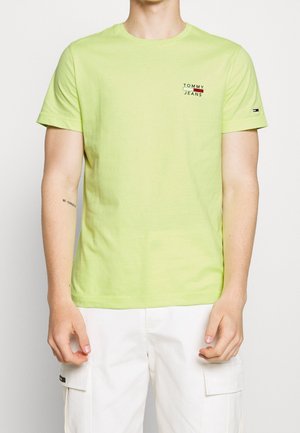 T-shirt en coton vert clair avec logo "TOMMY JEANS" en noir et rouge. Manches courtes et col rond. Texture lisse.