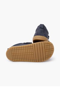 Scarpe in suede nero con suola in gomma, dotate di un motivo di grip testurizzato, bordi lisci e una robusta linguetta per una facile vestibilità.