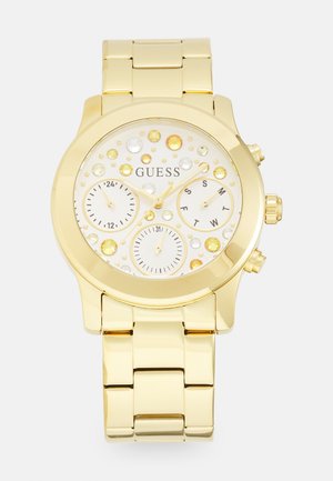 Gold-tone watch with a metallic link band, round face, white dial, multiple dials, and embellished with various clear and yellow stones.