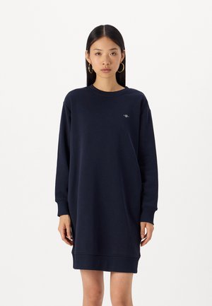 Abito felpa blu navy realizzato in materiale morbido, con scollatura rotonda, maniche lunghe e un piccolo logo sul petto. Vestibilità comoda.