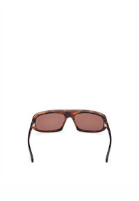 Sköldpaddsmönstrade solglasögon med rektangulära linser och brun ton. Rahmen har en blank finish och tunna svarta skalmar.