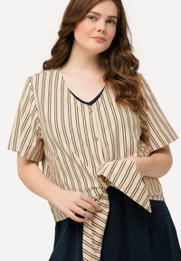 Beige stribet bluse med korte ærmer, v-hals og twist-front design. Har sorte striber og detaljer med træknapper.