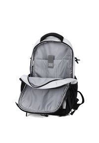 Zaino in bianco e nero con un ampio interno grigio, sezioni imbottite e una tasca anteriore con zip. Presenta spallacci regolabili e cerniere robuste.
