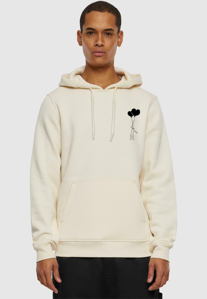 Cream hoodie made of cotton blend, featuring a front pocket and black graphic of a figure holding three balloons on the left chest area.