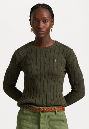 Maglione a coste in verde scuro con scollatura rotonda e polsini a costine, con un logo arancione sul petto. Indossato con una cintura intrecciata marrone.
