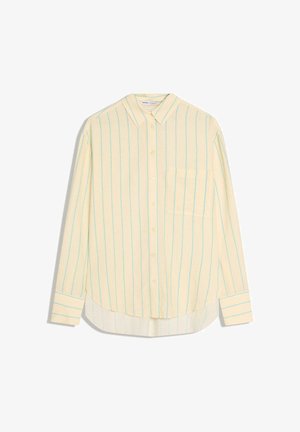 Żółta koszula z długim rękawem z jasnoniebieskimi pionowymi paskami, zapinana na guziki, z jedną kieszenią na piersi i zaokrąglonym dołem. Miękka w dotyku.