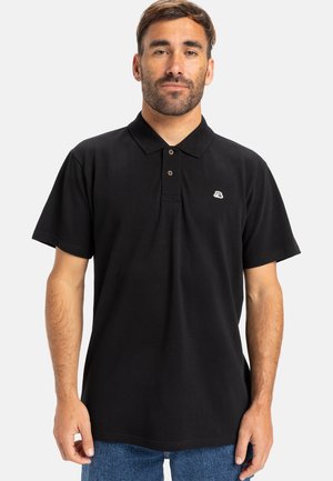 Sort polo-shirt med krave og tre knapper, med et lille hvidt logo på venstre bryst. Korte ærmer og blødt bomulds materiale.