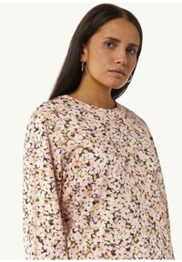Sweater met bloemenprint in pastelkleuren (roze, groen, beige) met een zachte textuur, ronde halslijn en lange mouwen. Opmerkelijke bloemenmotieven.