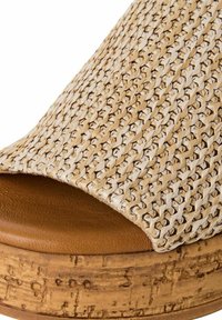 Upper in fibra naturale intrecciata di un beige chiaro con una piattaforma in sughero e un plantare in pelle marrone. Design open-toe con texture liscia e bordi curvi.