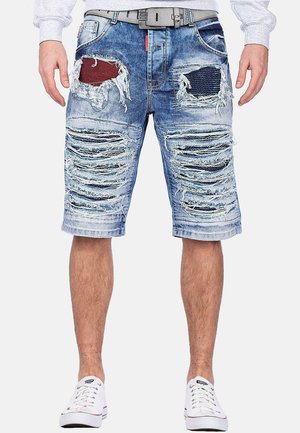 Shorts en denim bleu clair, avec plusieurs zones usées et des détails en patchs rouge et bleu marine. Dotés d'une ceinture et d'un ourlet effiloché.