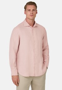Camicia in lino rosa pallido con maniche lunghe, bottone frontale e colletto a punta. Tessuto liscio con un sottile motivo a trama. Orlo arrotondato.