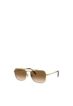 Occhiali da sole aviator in oro con lenti marroni sfumate, montatura in metallo e bracci texturizzati. Nostraglie trasparenti e logo visibile sulla lente.