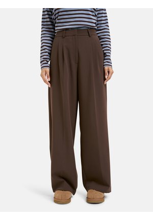 Brown wide-leg trousers with front pleats, smooth texture, high waist, and side pockets, paired with a striped long-sleeve top.