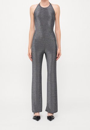 Metaliczny szary kombinezon z odkrytymi plecami na szyi typu halter, dopasowaną górą i rozkloszowanymi nogawkami. Materiał ma połyskującą teksturę, podkreślającą jego elegancki design.