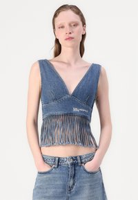 Top in denim tagliato con scollo a V profondo, orlo sfilacciato e dettagli frangiati. Logo "KARL LAGERFELD Jeans" ricamato sulla parte anteriore.