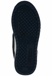 Schwarze Gummisohle mit texturiertem Grip-Muster. Enthält Logo und Patentschriften. Abgerundete Kanten und strukturiertes Design für Unterstützung.